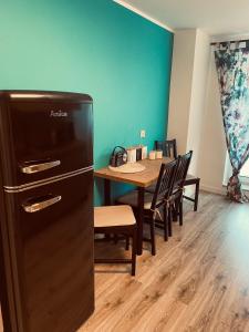 a dining room with a table and a refrigerator at Apartament Turkusowy in Puck