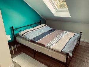 a bedroom with a bed with a blue wall at Apartament Turkusowy in Puck