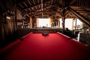 a pool table in a room with a red floor at Celeiro Guarapuava, 4 quartos, Paz e Tranquilidade in Guarapuava