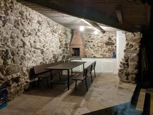 a dining room with stone walls and a table and chairs at Casa do Río in Bueu