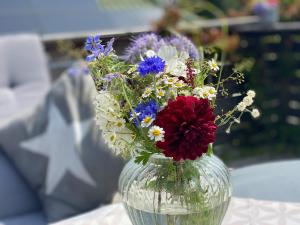 eine Glasvase mit Blumen auf dem Tisch in der Unterkunft Auszeit in Hürup