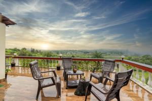 a balcony with four chairs and a table and a view at Nysa Villa Igatpuri in Igatpuri