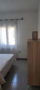 a bedroom with a bed and a wooden dresser at Da Anna in San Teodoro