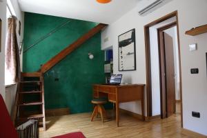 a room with a desk and a green wall at Vicolo degli Osci in Caserta