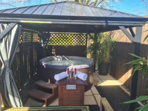 uma banheira de hidromassagem num gazebo com uma vela em Cypress Log Cabins Accommodation em Godshill