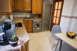 cocina con nevera y lavavajillas en Apartamento Cabanilles, en Villaviciosa
