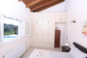 um quarto branco com uma cama e uma janela em Villa Sophia em Corfu Town