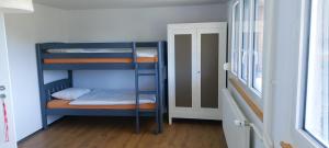 MontfauconにあるChambre d'hôte L'optimismeの二段ベッド2台とドアが備わる二段ベッドルーム1室を利用します。
