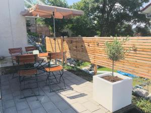 a patio with a table and chairs and an umbrella at LÜFTLE neue gemütliche große Familien Ferienwohnung im Allgäu in Wolfegg
