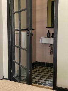 a bathroom with a glass door and a sink at Rallarhustruns in Hässleholm