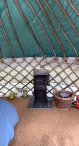 a bedroom with a tent with a stove in it at Yurt glyncoch isaf farm in Llangrannog