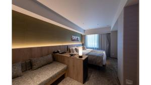 a hotel room with a bed and a couch at Iroha Grand Hotel Kintetsu Nara Ekimae in Nara