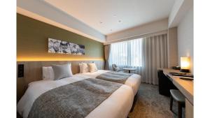 a hotel room with a large bed and a desk at Iroha Grand Hotel Kintetsu Nara Ekimae in Nara