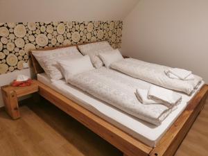 Una cama con sábanas blancas y almohadas blancas. en Naše Borovka, en Borová Lada
