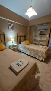 1 dormitorio con 2 camas y una lámpara en una mesa en Departamento Plaza 3 en Belén