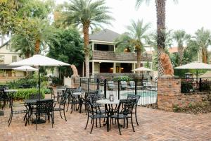 een patio met tafels, stoelen en parasols bij The Collector Inn (Adults Only) - Saint Augustine in St. Augustine