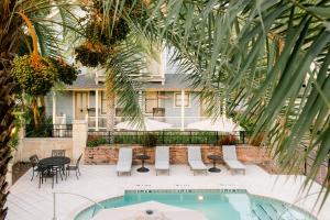 een binnenplaats met een zwembad en stoelen en een huis bij The Collector Inn (Adults Only) - Saint Augustine in St. Augustine