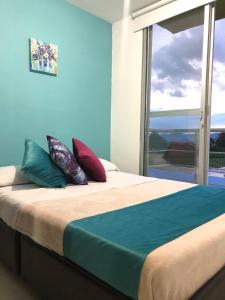 1 dormitorio con cama con almohadas y ventana en Apartamento Eje Cafetero a 2 km Parque del Café, en Montenegro