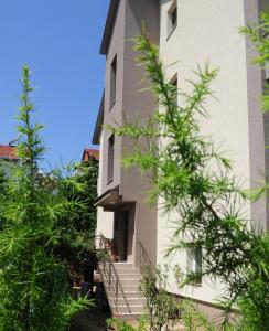 een gebouw met trappen en bomen ervoor bij Forest Apartments in Bitola
