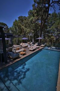 a swimming pool with couches and chairs next to a swimming pool at Fisher´s House Hotel in Avándaro