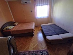 een kleine kamer met 2 bedden en een raam bij Apartman Djenovici in Herceg-Novi