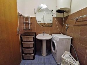 W łazience znajduje się umywalka, toaleta i lustro. w obiekcie Apartman Djenovici w mieście Herceg Novi
