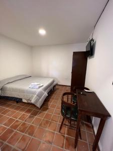 um quarto com uma cama, uma secretária e uma mesa em Donna Alda Casa em Salta