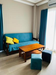 a living room with a blue couch and a table at Uptown in Kutaisi