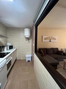 a living room with a couch in a kitchen at Apartamento Vida in Arenas de San Pedro