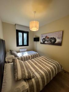 a bedroom with two beds and a motorcycle on the wall at Apartamento Vida in Arenas de San Pedro