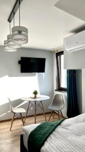 1 dormitorio con 1 cama, mesa y sillas en Aparthotel w Dolinie Stawów Zator by Housine, en Las