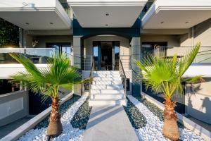 duas palmeiras em frente a uma casa em Blue Wave Luxury Suites em Iraklitsa