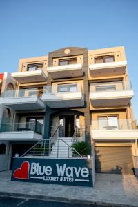 un edificio con un'insegna blu suite luxury di fronte di Blue Wave Luxury Suites a Iraklitsa