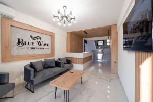 een woonkamer met een bank en een tafel bij Blue Wave Luxury Suites in Iraklitsa