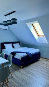 1 dormitorio con 1 cama con techo azul en Aparthotel w Dolinie Stawów Zator by Housine, en Las