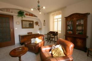 ein Wohnzimmer mit Ledersesseln und einem Klavier in der Unterkunft ALLOGGIO CASA IN PIETRA in Santu Lussurgiu