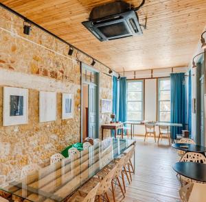 Habitación con mesas, sillas y pared de ladrillo. en TasEV Guesthouse en Lefkosa Turk