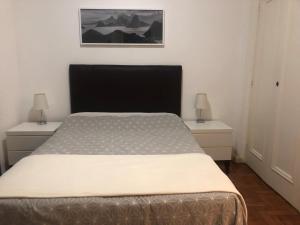 ein Schlafzimmer mit einem Bett und zwei Nachttischen in der Unterkunft Amazing in Ipanema by Verlaine Adami in Rio de Janeiro