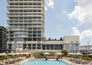 a hotel with a pool and a tall building at ROOST Tampa in Tampa