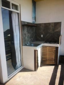a kitchen with a sink and a counter with a window at Namasté Zipolite Suites in Zipolite