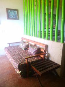 un banco sentado en una habitación con bambú verde en Namasté Zipolite Suites, en Zipolite