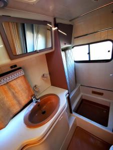 un piccolo bagno con lavandino e vasca di Rent a BlueClassics 's Campervan le Voyageur In Algarve au Portugal a Portimão