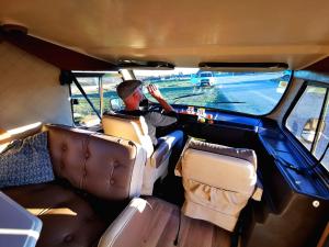 Un uomo seduto sul sedile posteriore di un furgone. di Rent a BlueClassics 's Campervan le Voyageur In Algarve au Portugal a Portimão