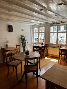 a dining room with tables and chairs and windows at Bett am Weiher in Wil