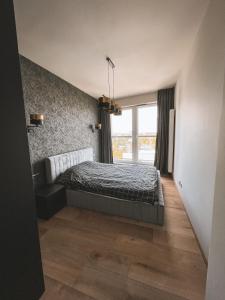 1 dormitorio con cama y ventana en Apartament en Katowice