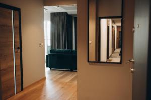 um corredor com um espelho e um sofá verde em Apartament em Katowice