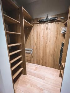 a walk in closet with wooden walls and shelves at Apartament in Katowice