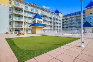 a large apartment building with a green lawn in front of it at Belmont Towers 505 in Ocean City