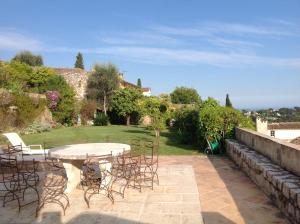 a patio with a table and chairs in a yard at La Petite Maison in Saint-Paul-de-Vence