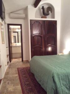 サン・ポール・ド・ヴァンスにあるLa Petite Maisonのベッドルーム1室(ベッド1台付)、大きな木製ドアが備わります。